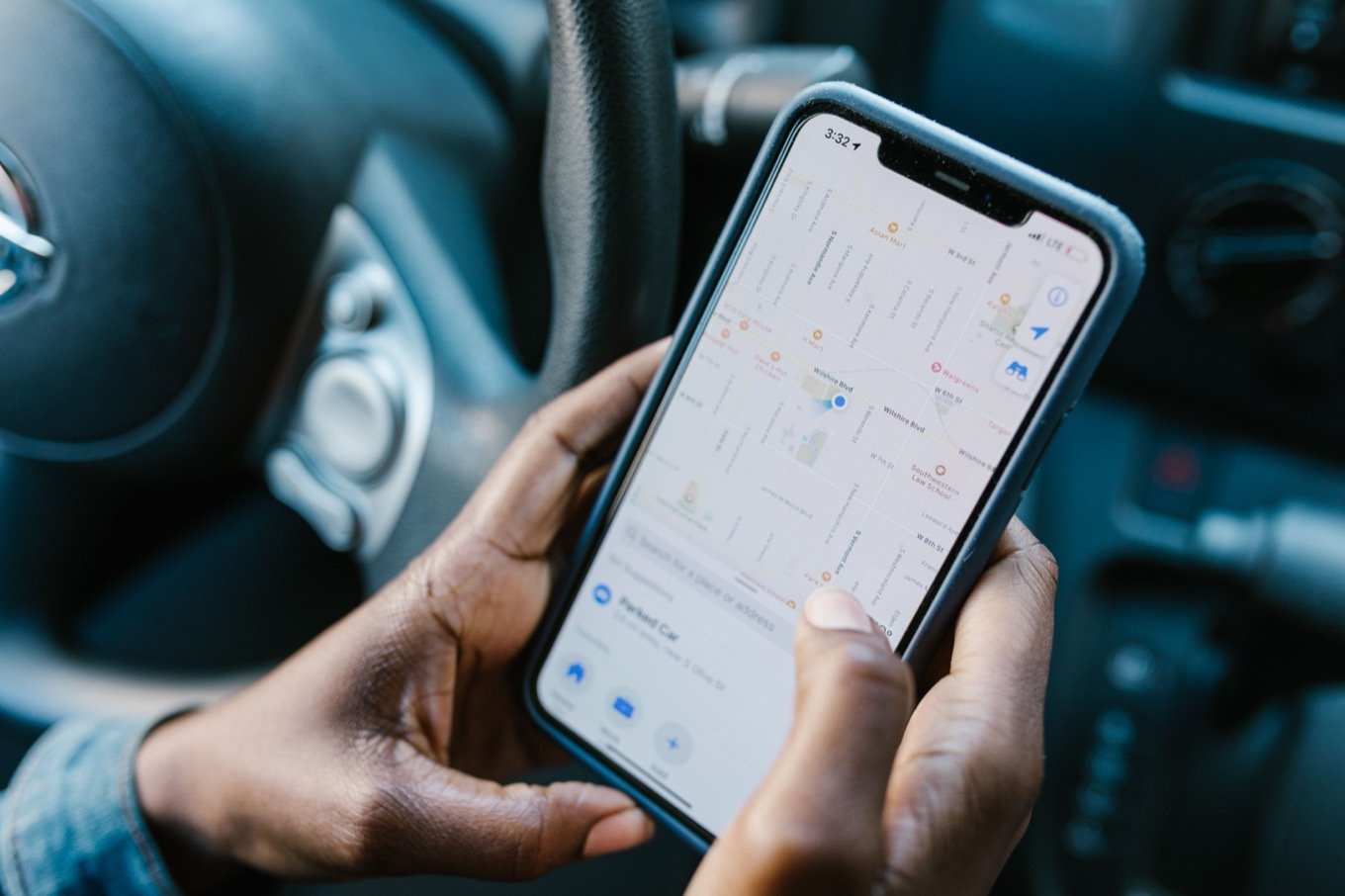 A driver following the live route on a phone map from the cab